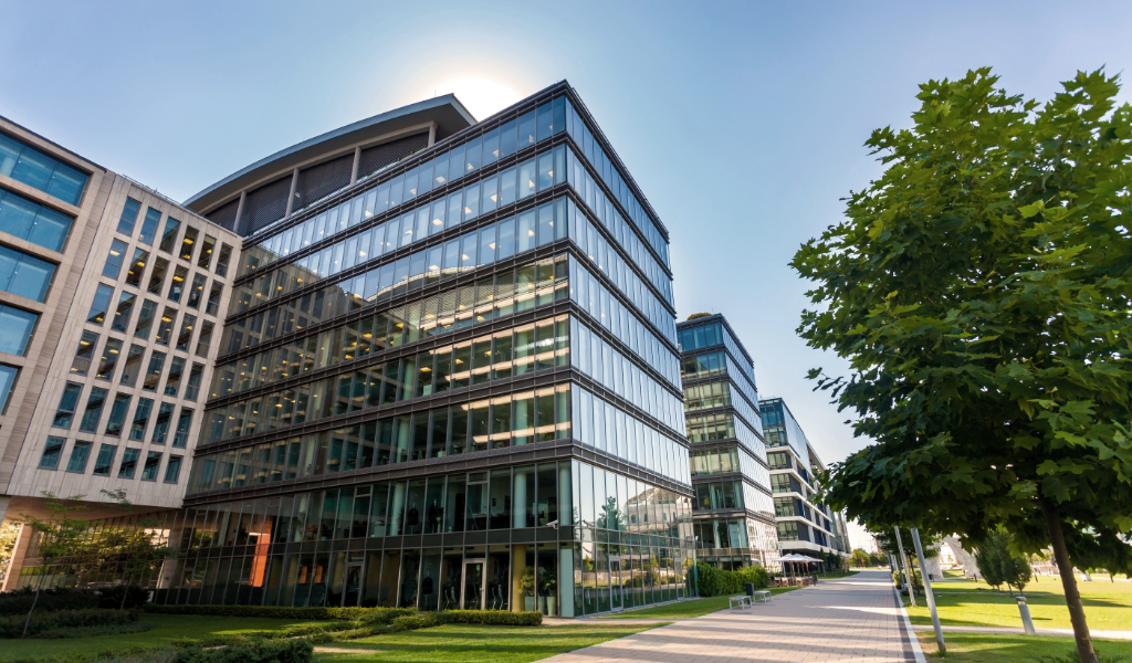 A tall commercial building against a clear blue sky, maintained by commercial property management services.